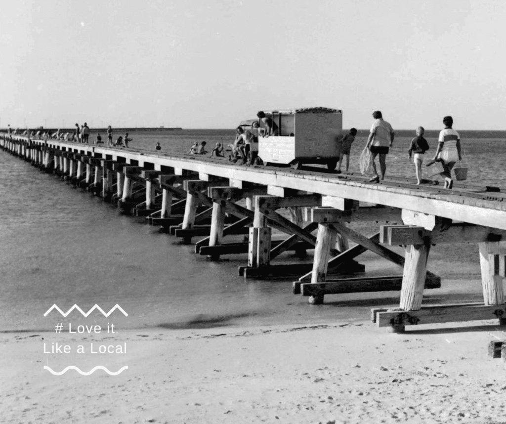 Old black-and-white photo of a wagon driving along the jetty
