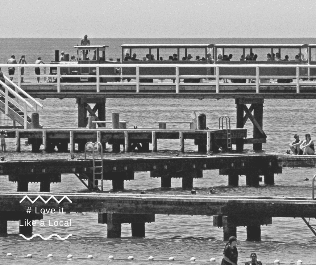 Old black-and-white photo of a train travelling along the Jetty